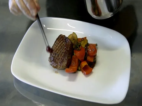 The chef decorated the steak with roasted vegetables. slow motion 動画素材 76056086
