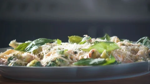 Chef decorates basil leaves with spaghetti pasta on plate in restaurant kitchen. 스톡 동영상 124711285