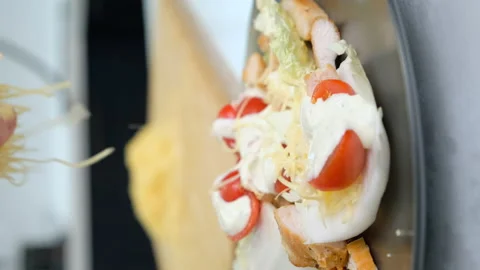 Chef Decorates Caesar Salad with Grated Cheese. Pours Cheese Straws onto Dish Stock Footage 147346011