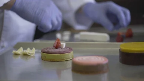Chef decorates cake berries with at the bakery Stock Footage 78029534