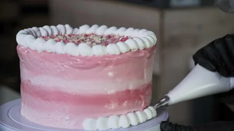The chef decorates the cake with careful wipe cream. 4K footage Stock Footage 231504887
