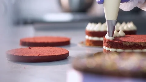Chef decorates a cake with cream at bakery, slow motion Stock Footage 121963027