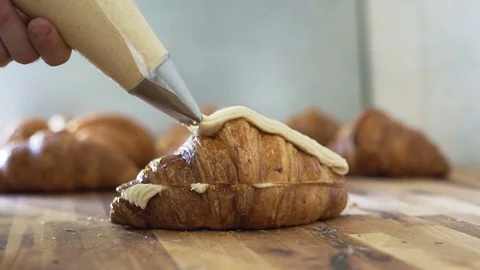 Chef decorates croissants with using cooking bag Stock Footage 78030382