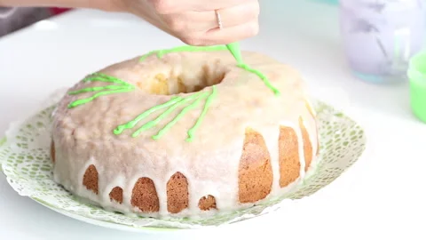 A chef decorates a cupcake with sugar icing. Applies green elements Stock Footage 130602777