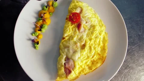 The chef decorates the dish with food, breakfast, egg omelet, with tomatoes Stock Footage 149408903