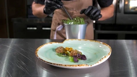 Chef decorates a platter with Greens Stock Footage 97881181