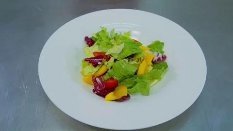Chef decorates the salad with tomatoes Stock Footage 70973114