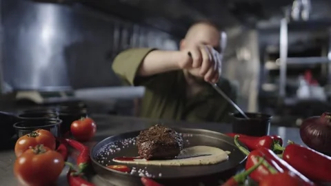 The chef decorates the steak with greens using tweezers. Stock Footage 240939695