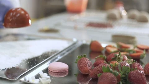 Chef decorates strawberry cake with coconut flakes at the bakery Stock Footage 121963490