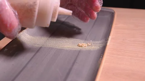 Chef decorates sushi serving plate with sesame seeds, microgreens and wasabi. Stock Footage 269562801