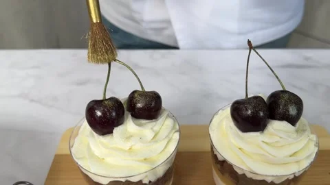 The chef decorates the trifle cake in cups with berries, creating confectionery Stock Footage 245536954