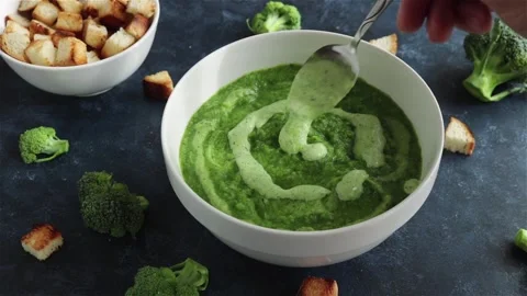 Chef decorating broccoli cream soup in white  bowl close up Stock Footage 120912860