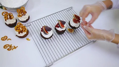Chef is decorating delicious cupcakes with red currant, figs and pistachios. Stock Footage 106614539