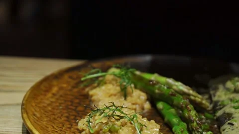 Chef decorating dish with green ruccula. Baked white fish dish with white sauce Stock Footage 222215681