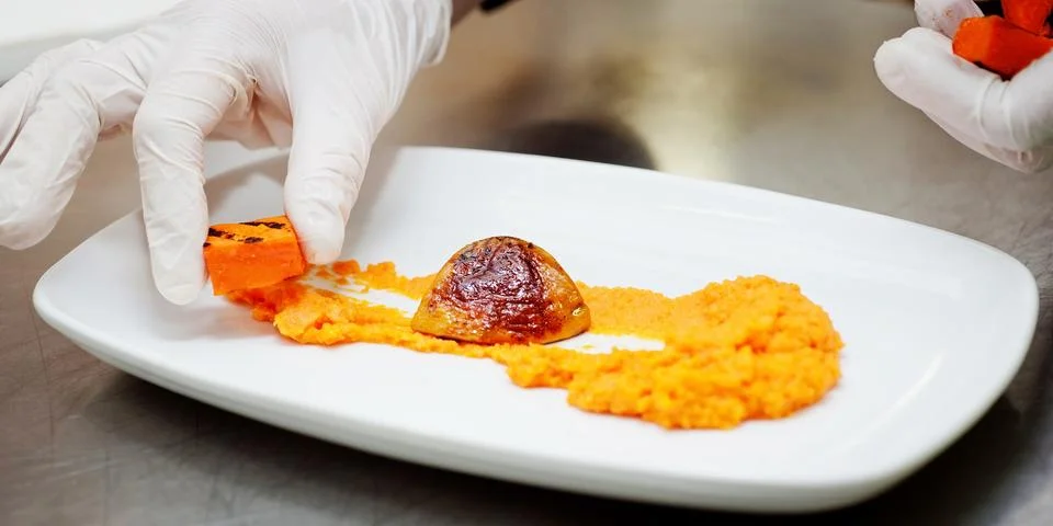 Chef is decorating a dish Stock Photos