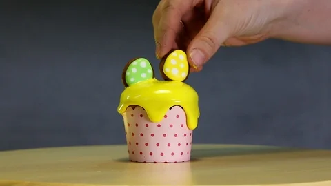 Chef is decorating festive yellow cupcake with gingerbread in the form of eggs. Stock Footage 90333932