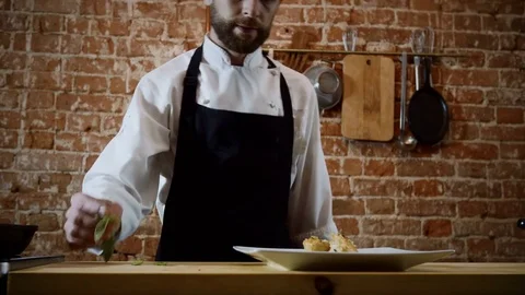 The chef decorating the finished dish of potatoes, cream, herbs and cheese. 4K Video stock 83152908