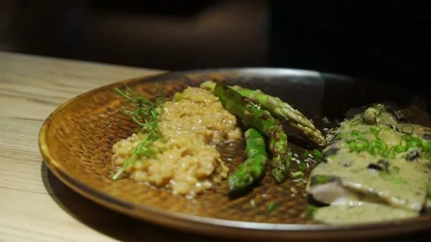 Chef decorating the fish dish with green salad with tweezers to serve in a Stock Footage 204818996