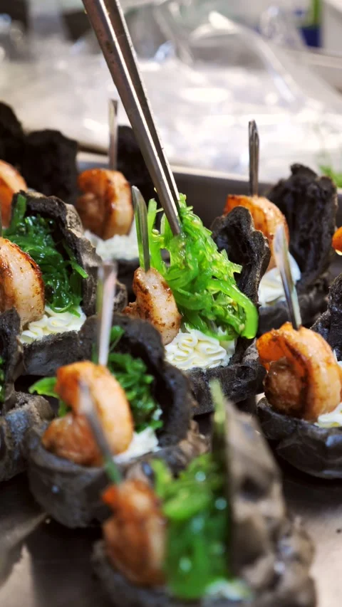 Chef decorating gourmet black tartlets with grilled shrimp and seaweed. Stock Footage 342029682