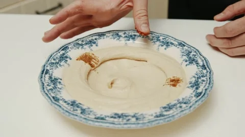 Chef decorating hummus plate with grinded paprika and parsley Stock Footage 206053408