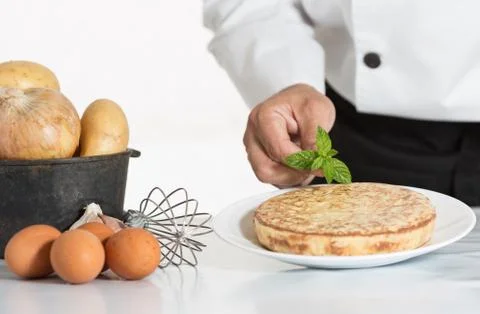 Chef decorating a potato omelette Stock-Fotos