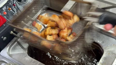 Chef deep frying bacon wrapped appetizers in a commercial kitchen fryer 動画素材 344100234