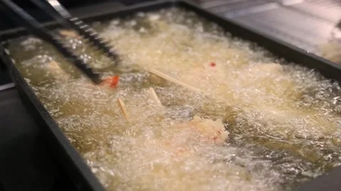 Chef Deep-Frying Crispy Tempura Shrimp in Hot Oil with Tongs Stock Footage 337440600