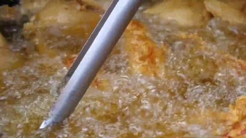 Chef Deep Frying Golden Battered Chicken Pieces with Tongs in Hot Boiling Oil Video stock 343587922