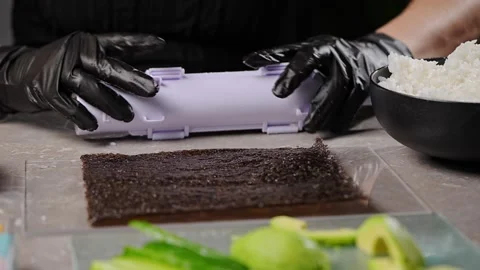 The chef deftly wraps a sushi roll in a sheet of seaweed Stock Footage 289539943