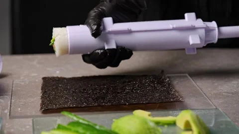 The chef deftly wraps a sushi roll in a sheet of seaweed Vidéo 289540130