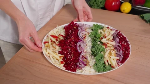 The chef demonstrates a salad of beets, apples, kale, and onions Stock Footage 265177293