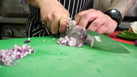 Chef dicing an onion for mise en place in a restaurant's kitchen 库存影片 203897119
