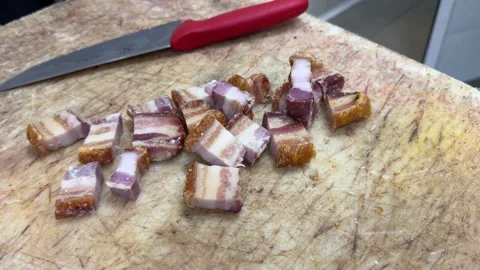 Chef dicing pork belly with a kitchen knife on a cutting board 스톡 동영상 344100186