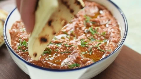 The chef dipping piece of bread  in roasted red pepper dip. Stock Footage 200810623