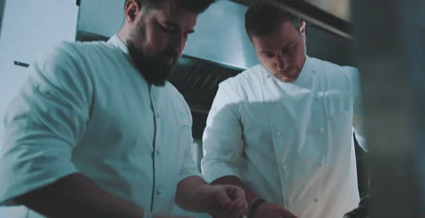 Chef disects herbs, chef 2 moves in the background Stock Footage 204973182