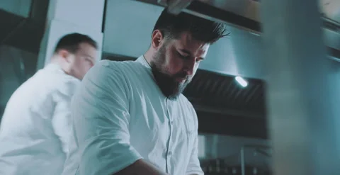 Chef disects herbs, chef 2 moves in the background Stock Footage 204973207