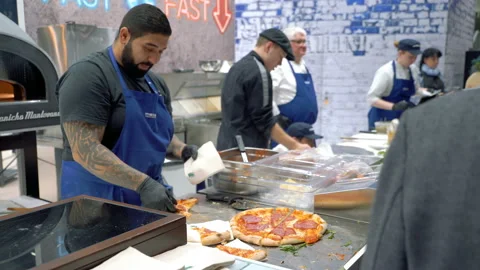 A chef distributes pizza samples to visitors Vídeo Stock 127806258