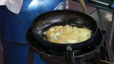 Chef doing fried egg using spade of frying pan in a pan Stock Footage 81674738