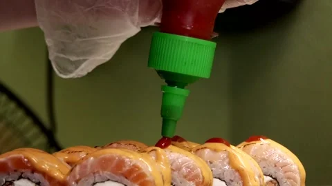 Chef dripping red sauce on delicious sushi on black plate close-up Stock Footage 285248970