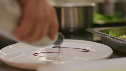 Chef Drizzling Balsamic Reduction on Plate while Serving Gourmet Dish Stockbeeldmateriaal 330062462