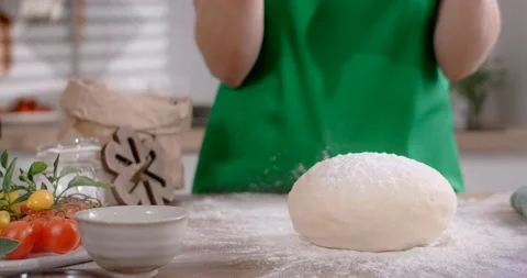 Chef drops the raw dough loaf to the flour at the kitchen in slow motion, 4k Stock Footage 168571796