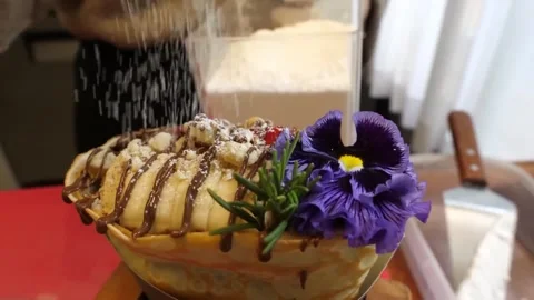 Chef Dusting Powdered Sugar on Gourmet Banana Chocolate Crepe Cone with Edible P Stock Footage 345692214