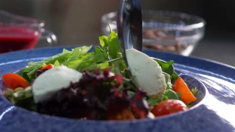 The chef at the elite restaurant forms a spring salad with meat under a bright Stock Footage 179704805