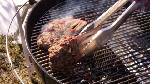 Chef expertly flips meat on grill showcasing precision and skill. Sizzle of Stock Footage 271112340