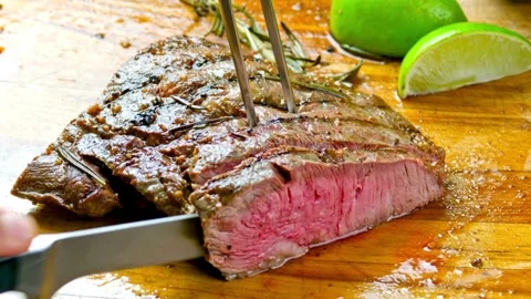 A chef expertly slices a delicious steak, the juices flowing as the knife cuts 库存影片 336582013