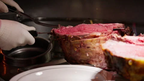 A chef expertly slices thick roast beef with a long knife and steak fork Stock Footage 282766666