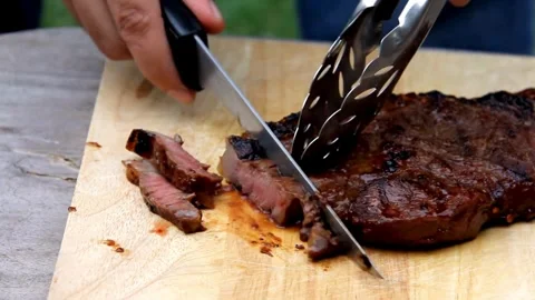 Chef expertly slicing a steak to create a tender, melt in your mouth cut. 4k Stock Footage 336581659