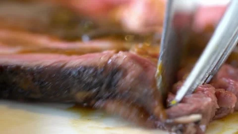 Chef expertly slicing a steak to create a tender, melt in your mouth cut. 4k Stock Footage 336581696