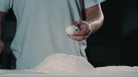 The chef of famous restraunt breaks the egg into flour. Stock-Footage 92579005
