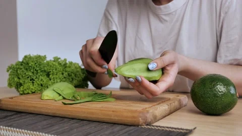 Chef female is using a knife to peel an avocado. Stock Footage 150789685